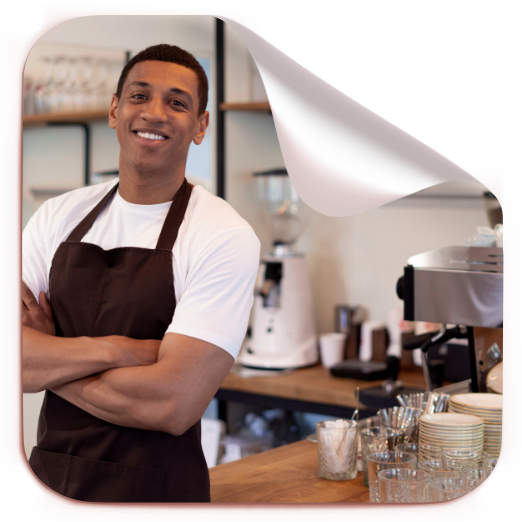 Jovem de avental sorrindo em um espaço de cafeteria.